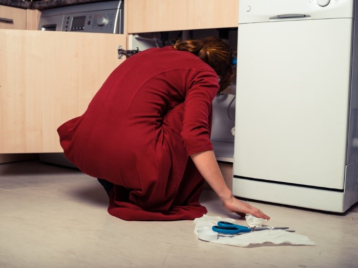 woman cleaning under the sink