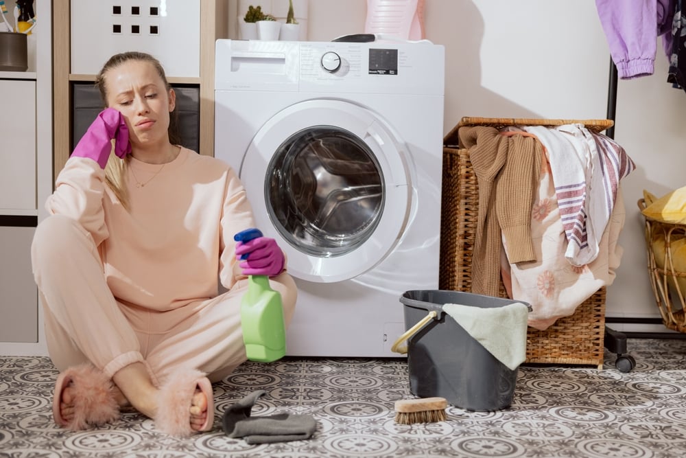 woman looking sad in front of dryer